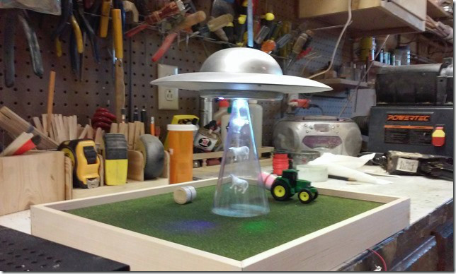 A model of a spaceship sucking up cows.