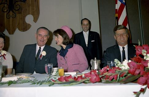 A photo of Jackie Kennedy talking to Lyndon Johnson at a banquet.