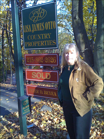 A photo of Nancy Birnes in front of our house's Sold sign.